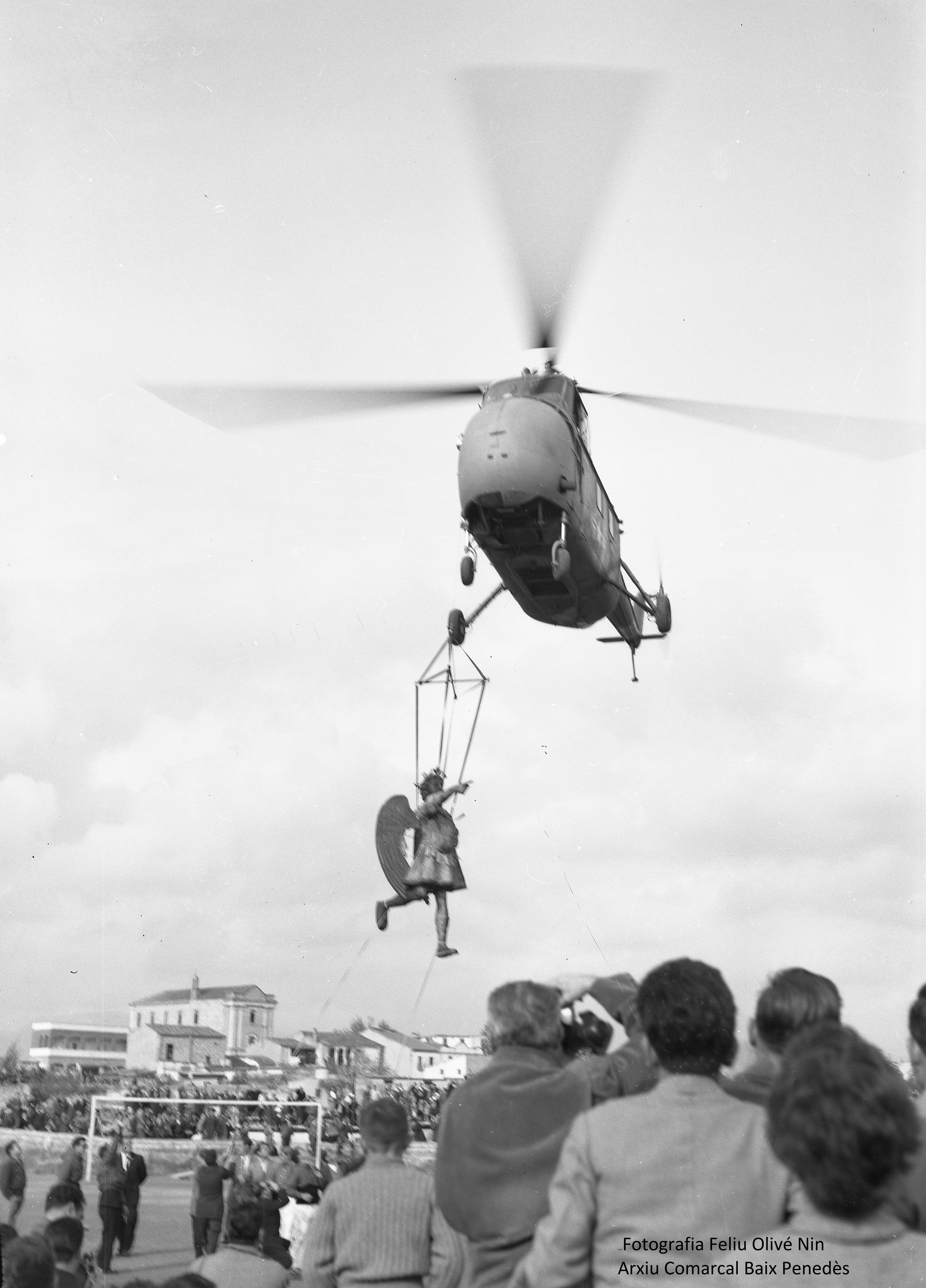 Helicòpter enlairant-se alhora que enlaira l'Àngel de Tobies per col·locar-lo a dalt del campanar de l'Esglèsia de Sant Salvador. Any 1954